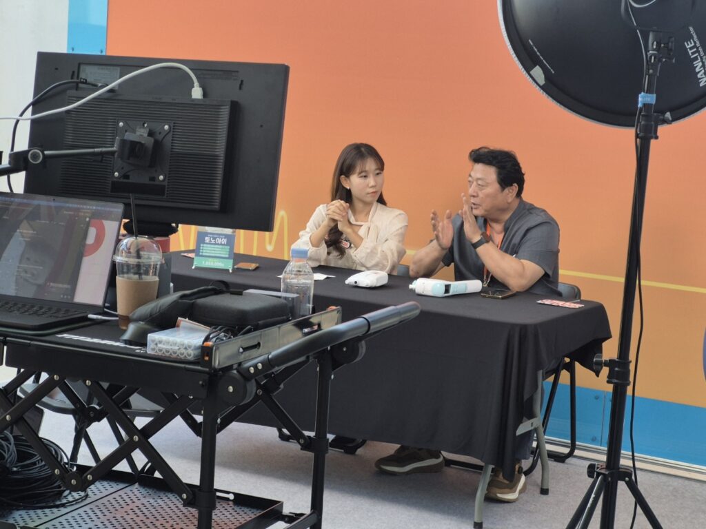 조명과 카메라 장비 앞에서 토노아이 제품을 시연 및 인터뷰하고 있는 라이브 방송 현장